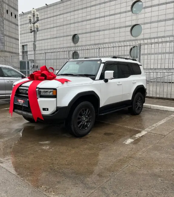 Белый автомобиль клиента с красным подарочным бантом